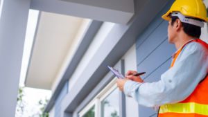 The inspector or engineer is checking the building structure and house roof specifications. After the renovate is complete