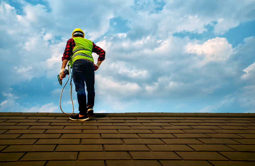 Professional technician Roof repair Standing action on the roof top Hold the drive screw tool in hand