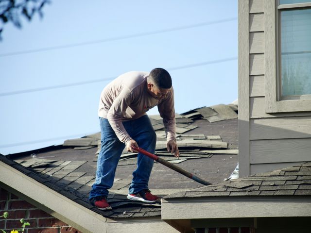 roofing contractor removing damaged roof