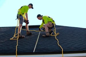 two men installing asphalt roof